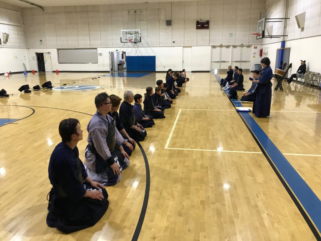 Norwalk Kendo Dojo at the end of practice. Students are lined up in rank order while receiving general guidance from head instructor Kodama, standing at right.