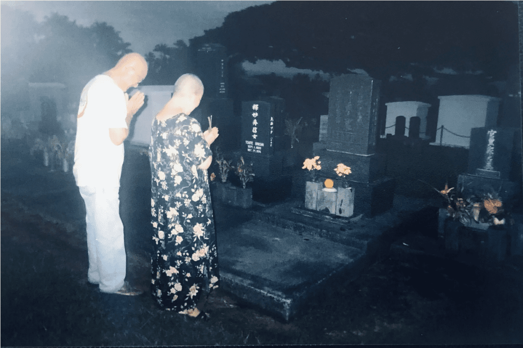 Hasegawa’s parents visiting a cemetery. Her father, a construction worker/surveyor, and her mother, a nurse/housewife, had encouraged their civics-oriented daughter to get a master’s degree to be practical. She did, but in creative writing, producing a visionary political book of poetry, the well-reviewed “La Chica’s Field Guide to Banzai Living.”